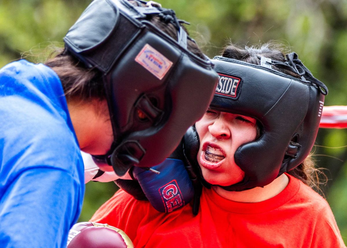 Salma Flores (blue) lands a punch on Lianna Chavez's (red) jaw during the Boxing Club's Spring Semester Sparring Exhibition outside of the Loftin Student Center April 24. Photo by A. De Leon.
