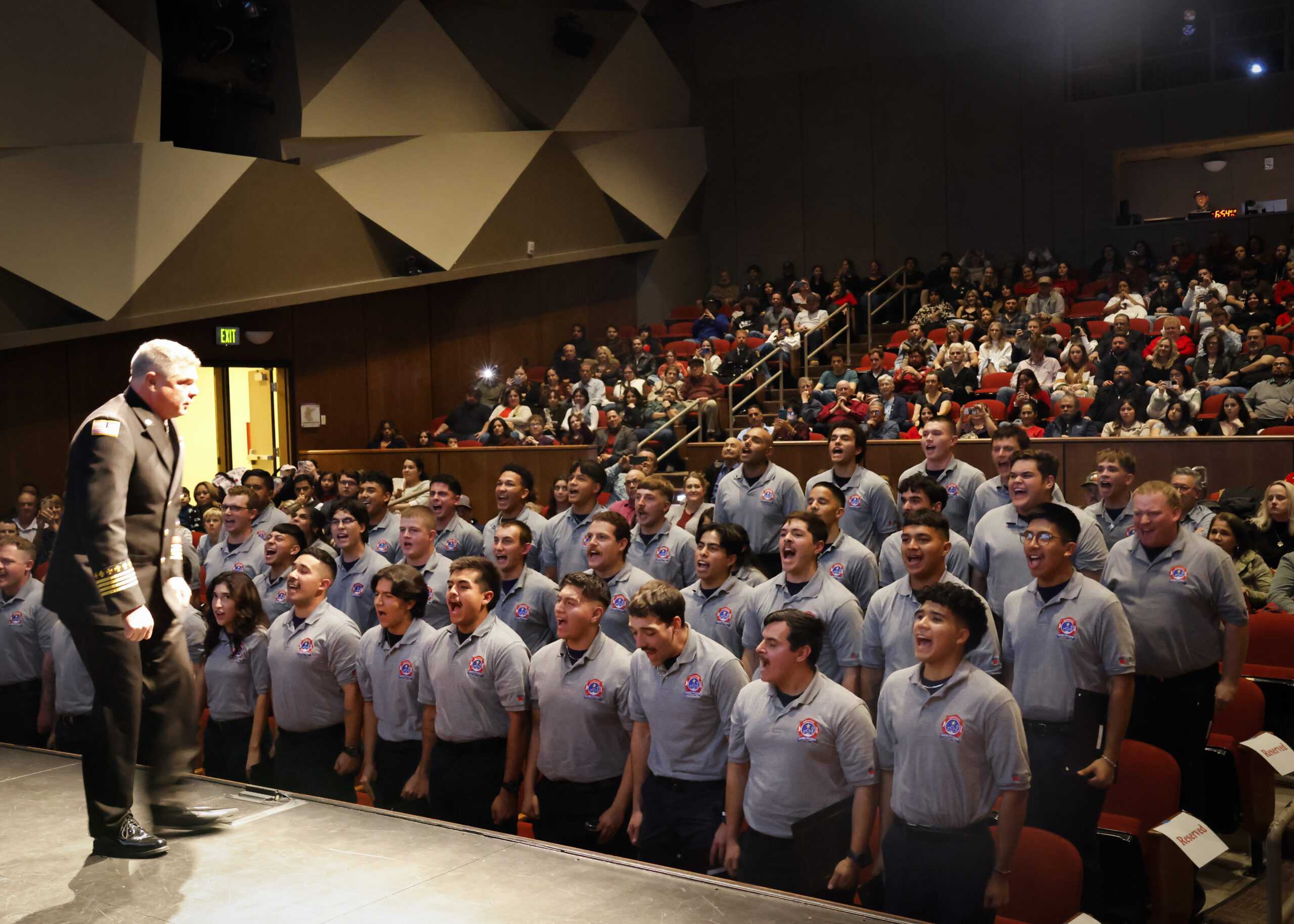 Frank L. Poyner, director of SAC’s Regional Fire Academy, leads a chant with graduating cadets at the Fire Academy graduation ceremony at Northwest Vista College Dec. 13. Photo by Natalia Edwards.