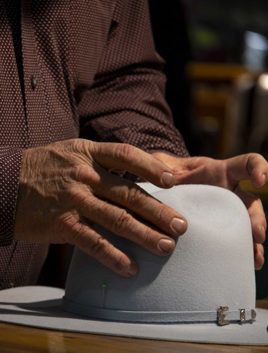 Billy Treadwell, an employee for the Heads or Tails Hats Boutique, shapes a hat for a customer in the Expo Hall at the San Antonio Stock Show and Rodeo Feb. 12. Photo by Itzabel Lara