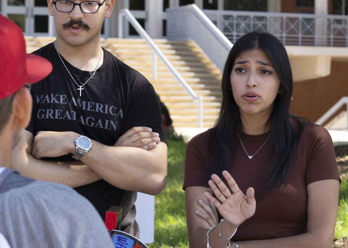 SAC student Roberto Lopez Jr., foreground, speaks with Turning Point USA members in the SAC mall area Wednesday. Photo by Charles Hopper.