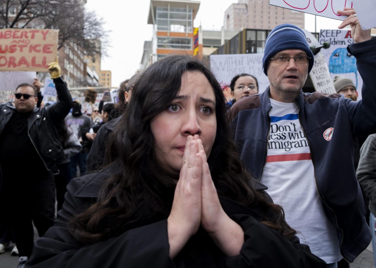 A protester prays during the ICE Out protest on Friday where hundreds gathered against recent fatal shootings involving federal agents in Minneapolis. Photo by Jacob R. Lopez.