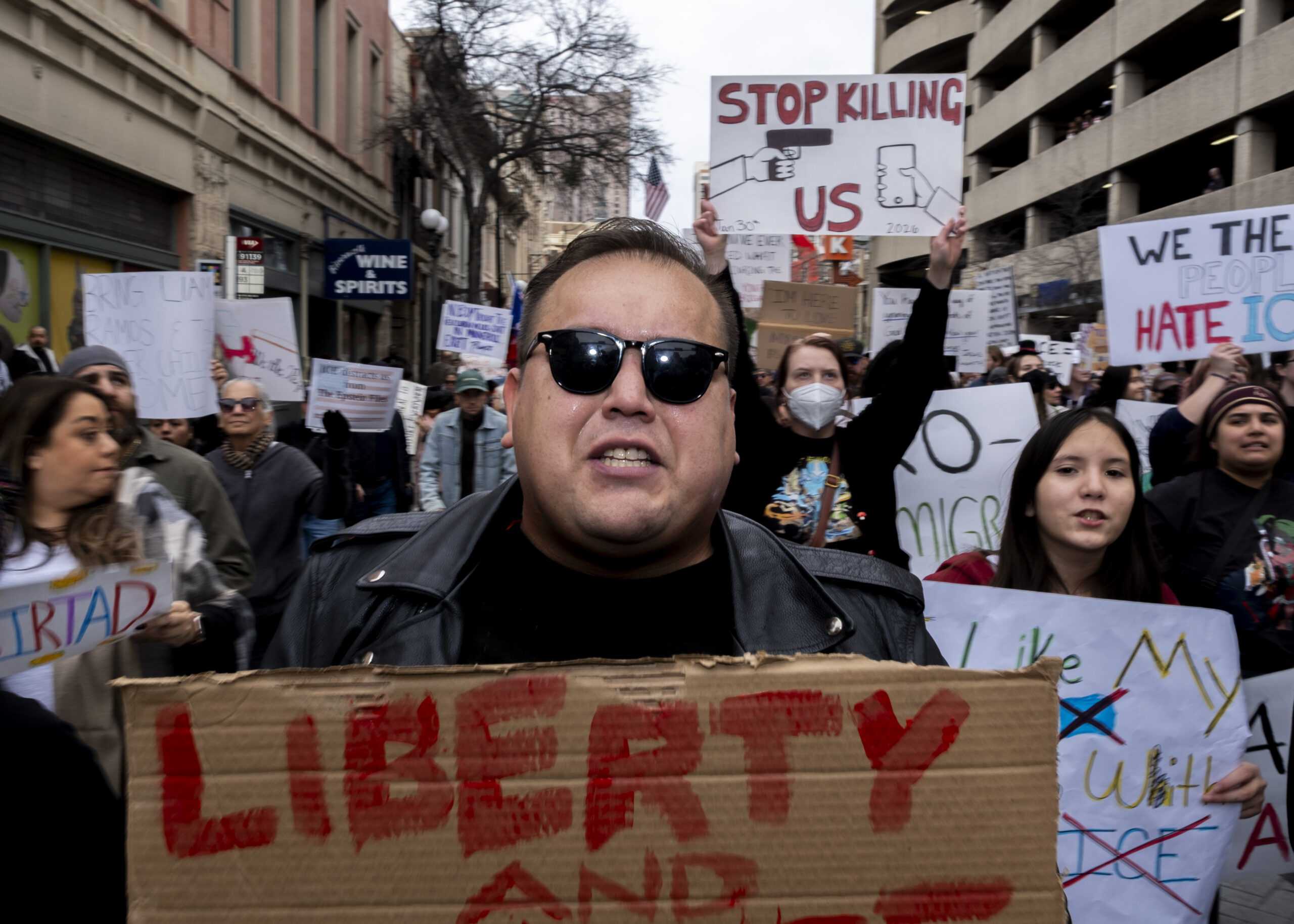 A protester marches down W Market as hundreds gathered in protest against recent fatal shootings involving federal agents in Minneapolis. Photo by Jacob R. Lopez.