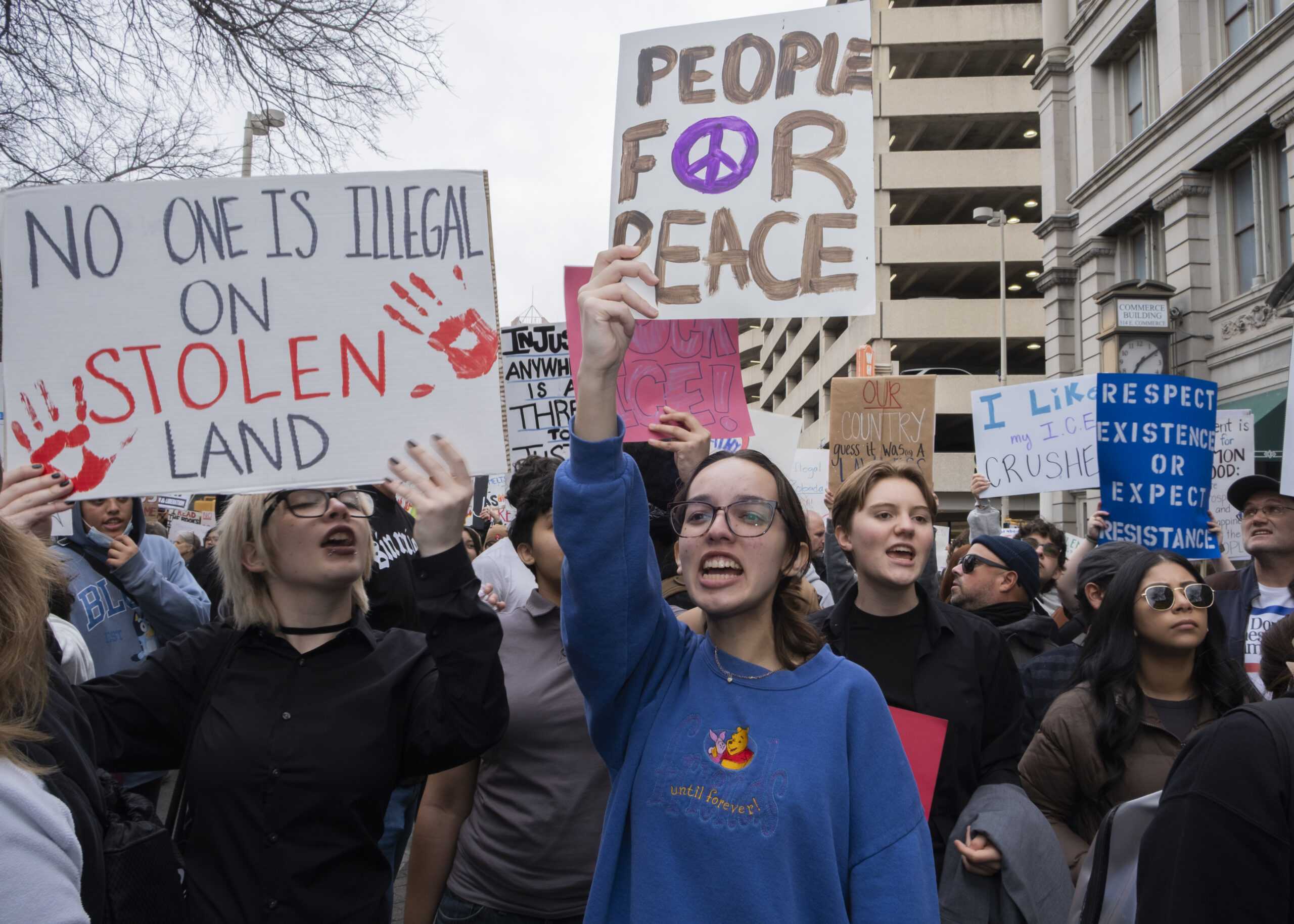 A protester marches down W Market as hundreds gathered in protest against recent fatal shootings involving federal agents in Minneapolis. Photo by Jacob R. Lopez.